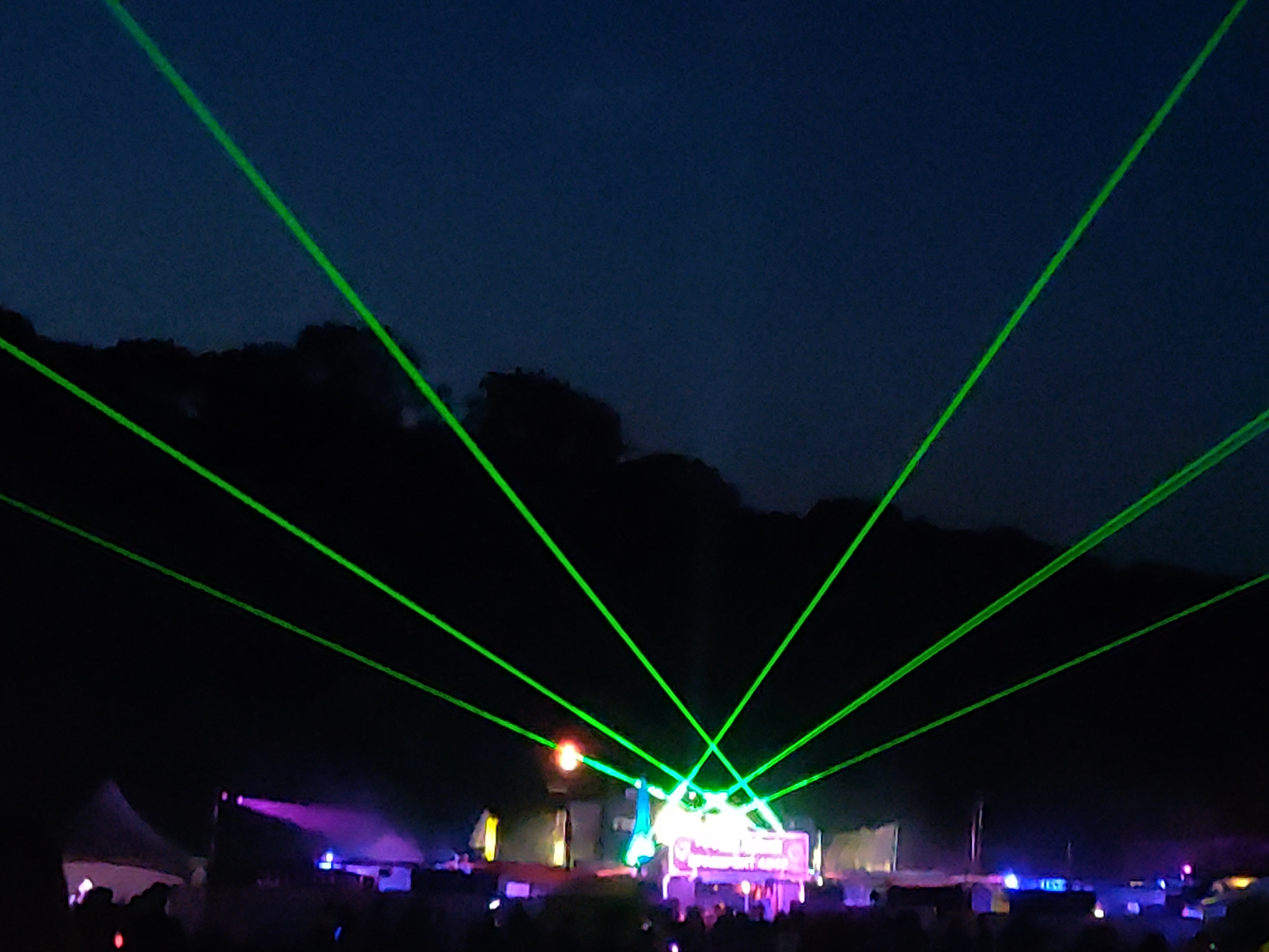 A low quality photo of lasers in the sky