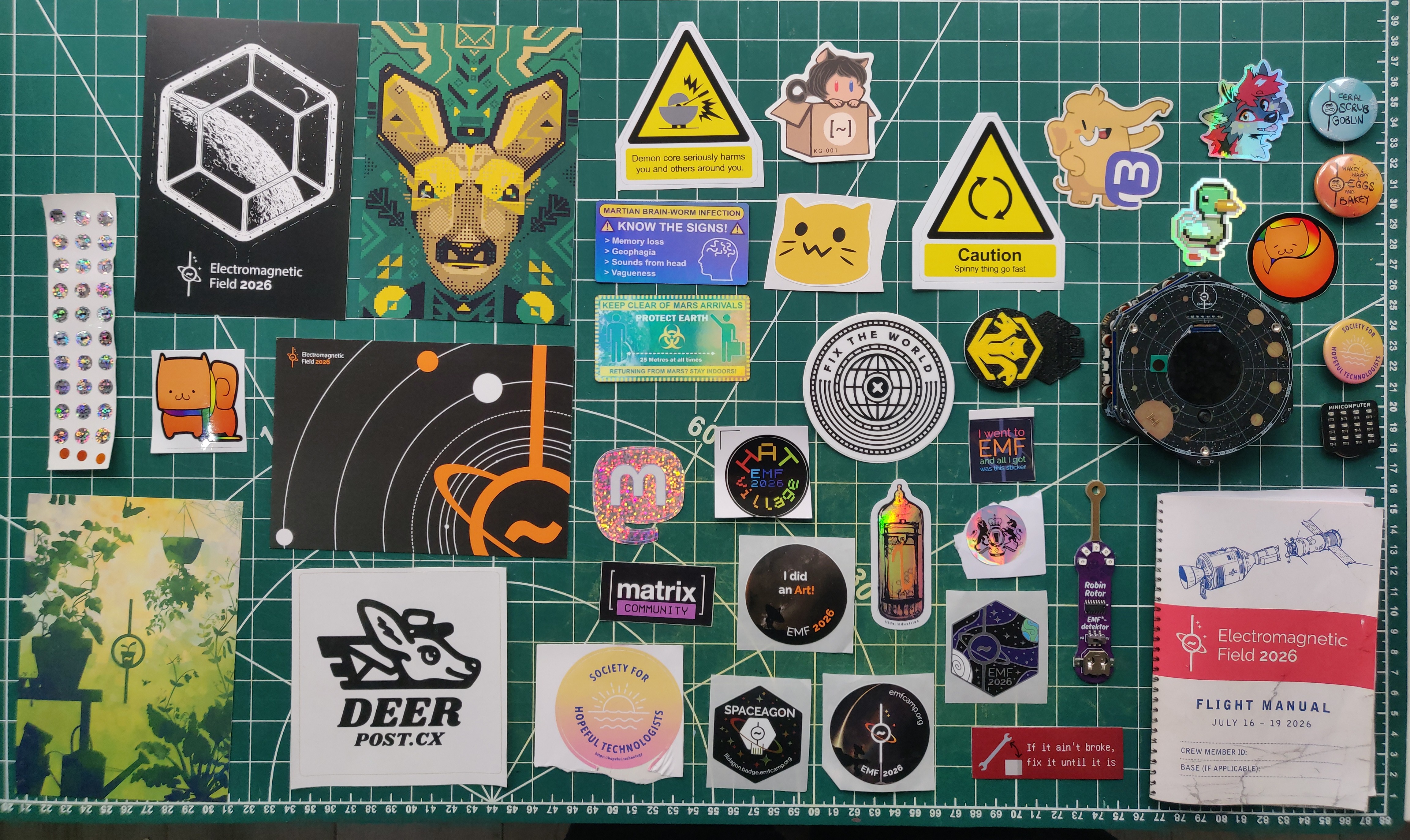 Stickers, postcards, badges, and miscellanea laid out on a table.